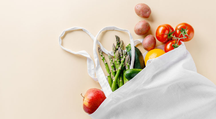 Fotografia de sacola retornável com frutas e legumes.
